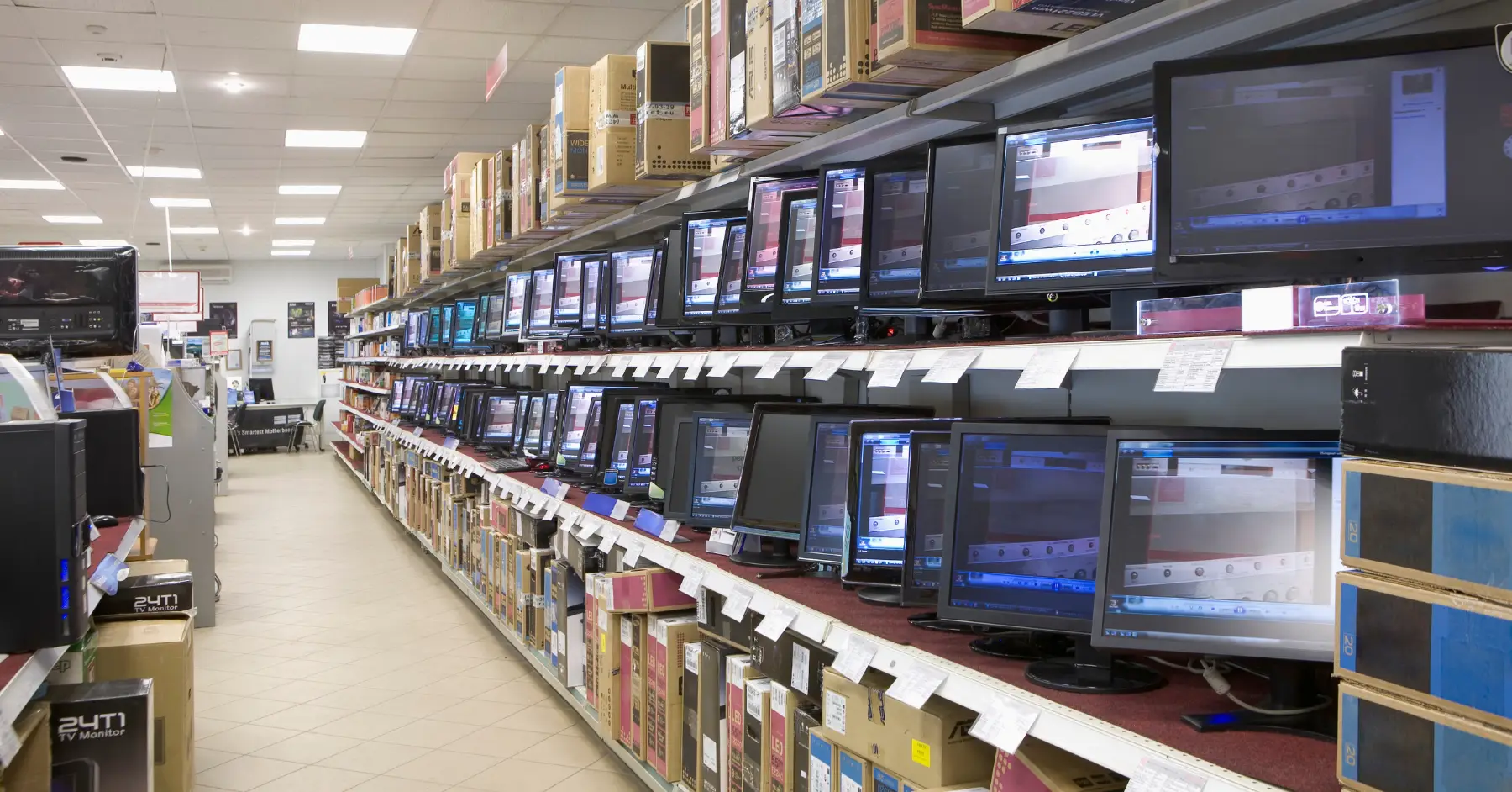 Interior of a consumer electronics store with rows of television screens displaying colorful images.
