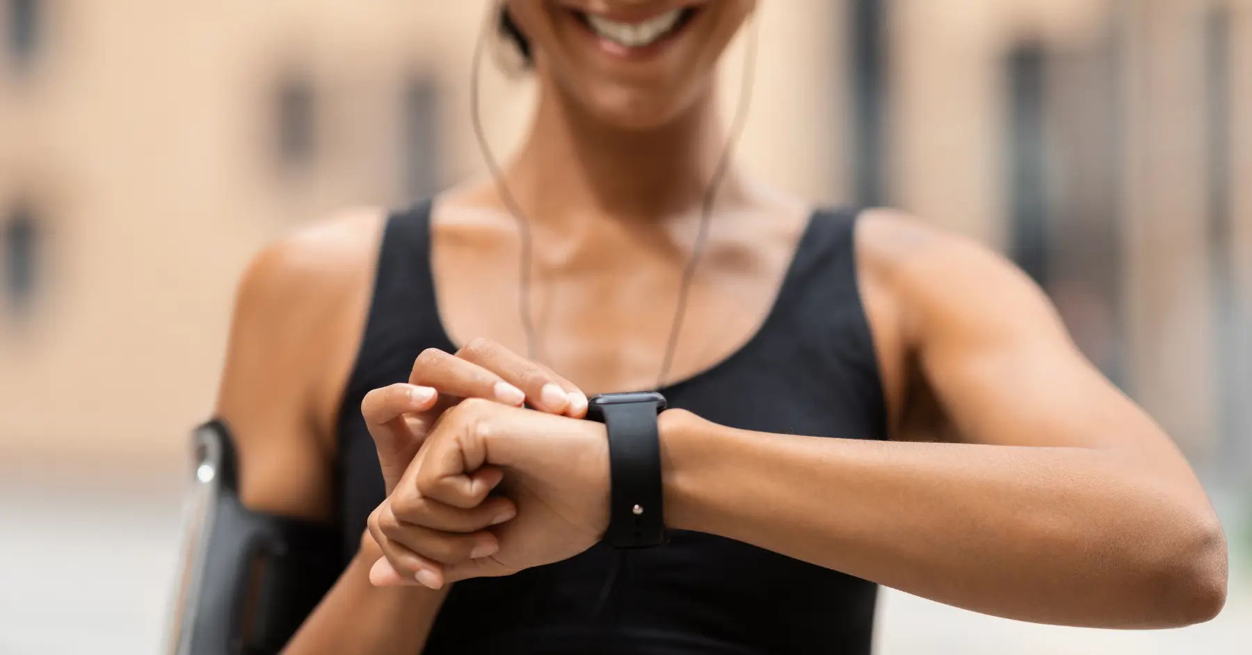 Woman smiling while checking her smartwatch during a workout.