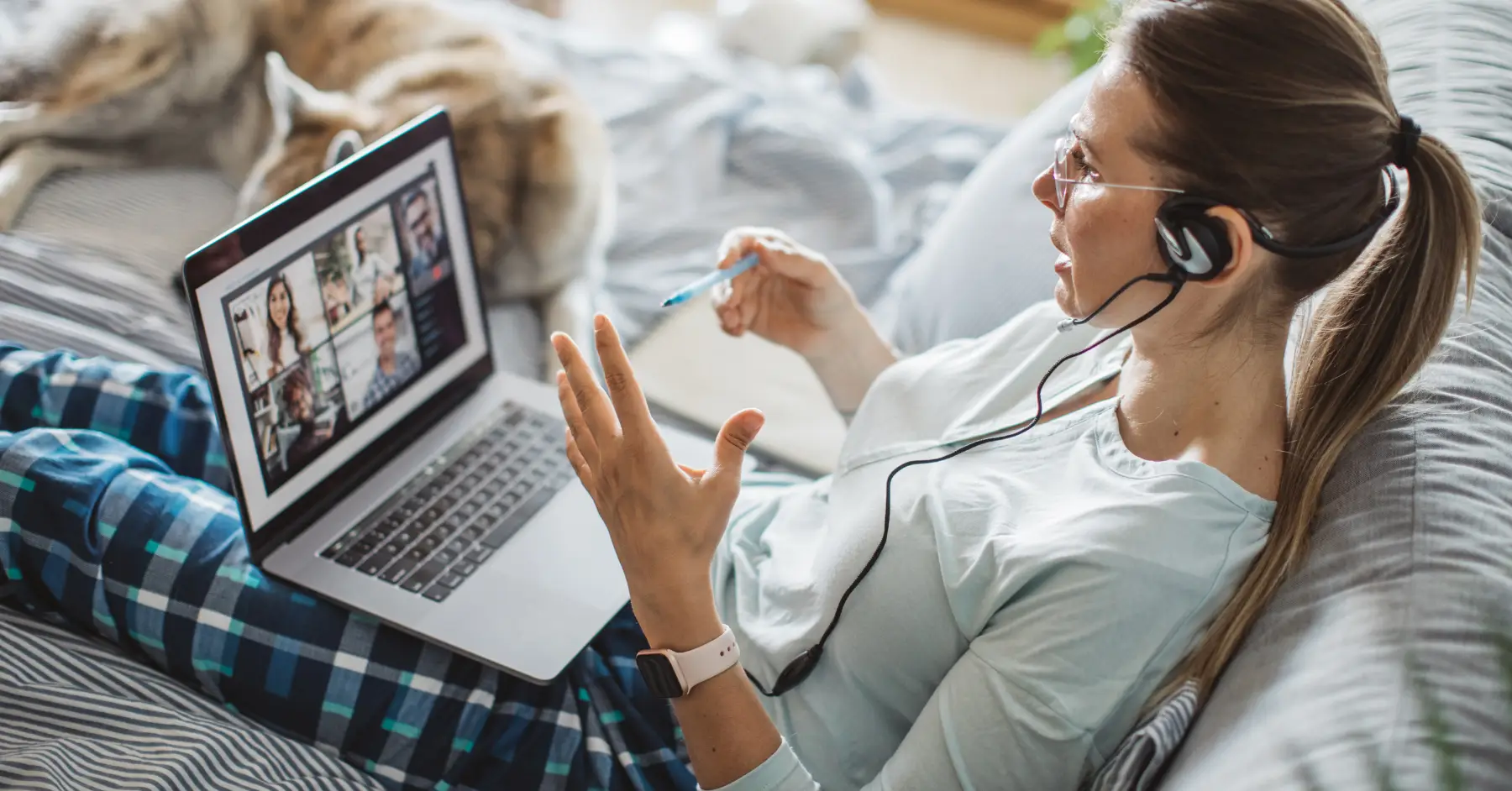 Woman participating in a virtual meeting from home, reflecting the shift towards remote work enabled by technology during the pandemic.