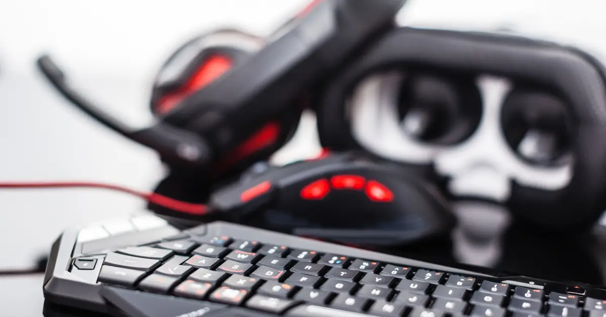 Close-up of a gaming headset, mouse, and mechanical keyboard, essential tools for enhancing the PC gaming experience.