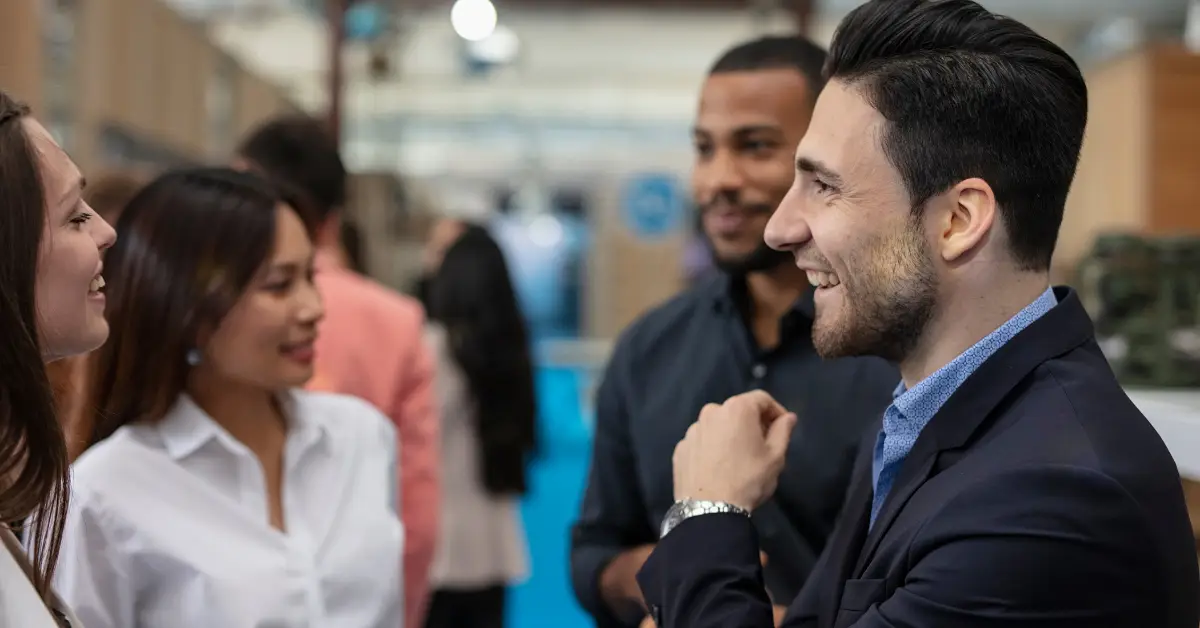 Business professionals networking and engaging in conversation at a tech industry event.